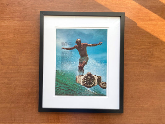 1978 Rolex "Red" Submariner Ref. 1680 with Surfer Advertisement in Black Wood Frame