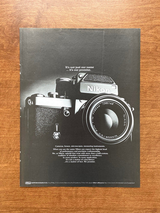 1973 Nikon "It's not just our name..." in black and white Advertisement